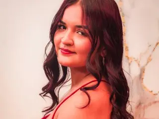 AlissonContreras smiles at the camera with her long wavy dark hair while wearing a red top.