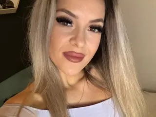 AlletaLove poses close-up, showing her blonde hair and face with a soft smile against a neutral background.