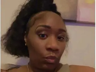 AmberDi looks into the camera with her dark hair pulled back in a messy bun.