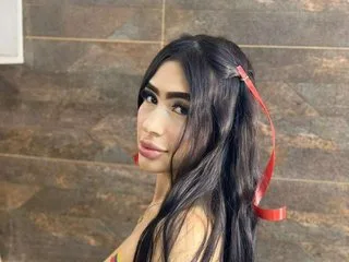 AmberRosen poses with her long dark hair swept to one side, looking toward the camera with a slight smile.