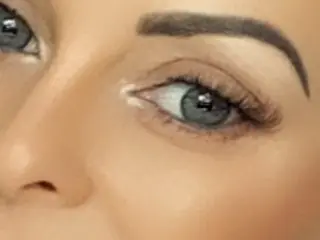 AmyJ shows a close-up view of her eye, dark eyebrows, and eyelashes.