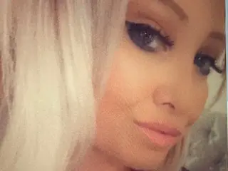 AngelEyesUK poses for a close-up selfie, showing her face, blonde hair, and dark eye makeup.