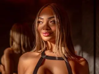 Anna_Jenssen poses with her long blonde hair down, wearing a black halter-style top that shows off her cleavage and shoulders.