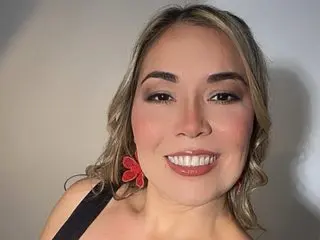 Anna_Luu smiles at the camera, showing her face and light brown hair against a plain grey background.