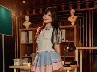 AprilSloane poses in a light blue and white lace outfit with long dark hair against a warm wooden background.