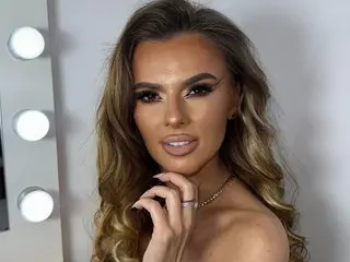 AprilXXS poses with her long wavy hair, showing her face and shoulders in a close-up shot.