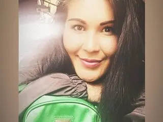 AriannaAdames smiles close up, showing her long dark hair and face in a bright indoor setting.