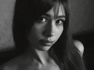 AriiaTyler looks into the camera with a sultry expression in this close-up black and white portrait.