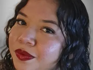 Aurorarios poses with a close-up view of her face, showing her dark wavy hair and red lipstick.