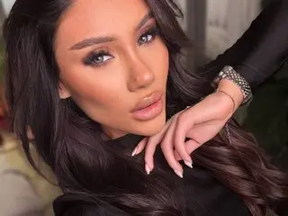 AvaHeath poses close-up, looking at the camera with long dark hair and a black top.