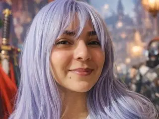 AzulMony poses with her long, light purple hair framing her face, looking directly at the camera with a slight smile.