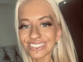 BabeBeth40 smiles with her blonde hair down, showing off her nose ring and lip piercing.