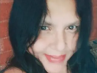Barbarasinns smiles with long black hair, showing her face and shoulders in a close-up shot.