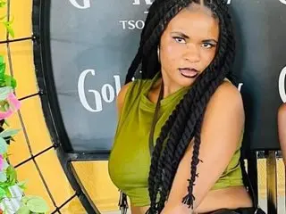 BestLia poses with her long dark braids, wearing a green sleeveless top against a dark circular background.