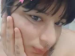 BigCurvysquirting looks into the camera with her hands framing her face, showing her dark hair and light skin.