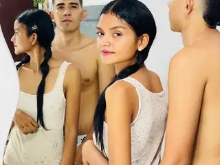 BlakeAndRuby, a woman with long black hair in a side braid, wearing a white tank top, posing against a plain background.