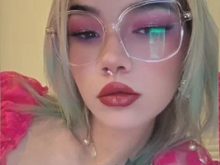 Boobooxbunny poses with a close-up view of her face, showing her pink eyeshadow and light green hair.