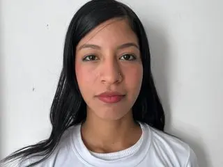 Brookeestar poses with long black hair, wearing a white t-shirt against a plain white background.