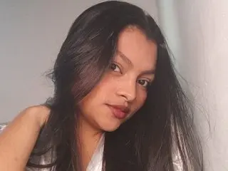 Candela34 poses with her long dark hair falling over her shoulders, looking toward the camera with a soft expression.