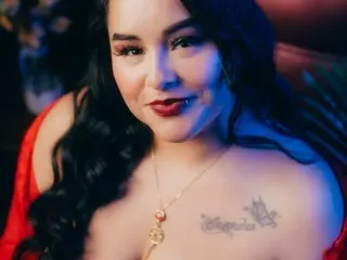 Celesttebeautiful smiles at the camera with long dark hair and a tattoo on her chest while wearing a red top.
