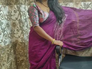 Woman in elegant magenta silk saree and patterned blouse posing indoors for a traditional ethnic look.