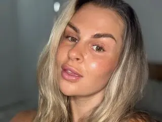 ClaraXVale poses with a close-up headshot, showing her blonde hair and clear skin with a soft glow.