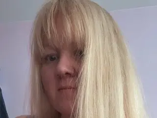 CurvyDanielle shows her long blonde hair and face in a close-up shot against a plain background.