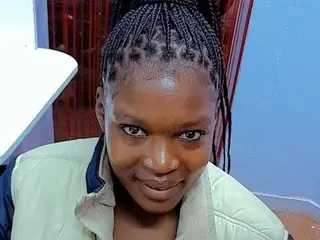 Cutefoxgirl looks at the camera with a smile, showing her face and hair styled in thin braids or cornrows.