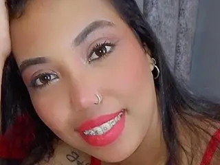 DafneLuna smiles closely at the camera, showing her face, dark hair, and red lipstick.