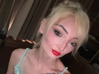 DaisyHart poses with her blonde hair down, wearing a light blue lace bra and looking directly at the camera.