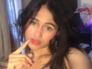 Danielahot22 looks at the camera with long dark hair and red lipstick.