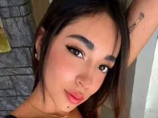 DaniielaPerez poses close-up, showing her face, dark hair, and light makeup with a small mole on her chin.