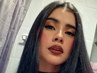 DashaRodriiguez poses close-up with long dark hair and heavy makeup, looking directly at the camera.