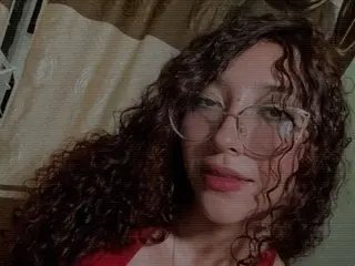 Dayannaarg shows her curly hair and face while wearing glasses in a close-up shot.