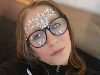 DianiSosa looks directly at the camera wearing thick black-rimmed glasses and a black top.
