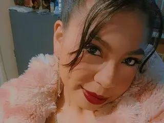 Dulcenea19 poses close-up, showing her face and dark hair against a soft pink furry collar or shrug.