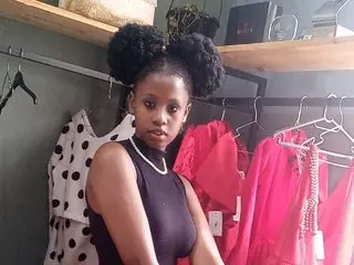 EbonyPoisonCunt — EbonyPoisonCunt poses in a black sleeveless top with her hair in two large afro puffs in a walk-in closet.