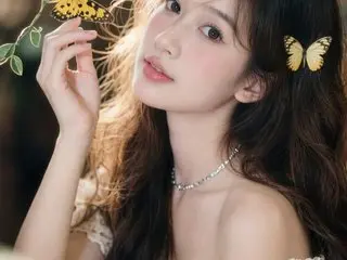 Dreamy portrait of a young woman with butterfly hair clips holding a yellow butterfly in soft sunlight.