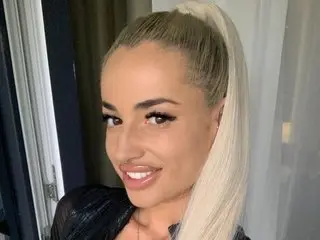 Elisabethpretty poses with her long blonde hair pulled back in a high ponytail, smiling at the camera in a close-up shot.