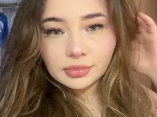 Elisacolevanss poses close-up, showing her face and long brown hair against a neutral background.