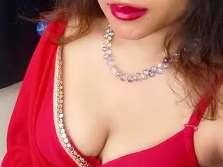 Elitequeen — Elitequeen poses in a red top with silver trim, showing off her cleavage and dark hair.