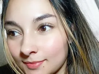 ElizabethWhiite looks directly at the camera with a soft smile, showing her face and long dark hair.