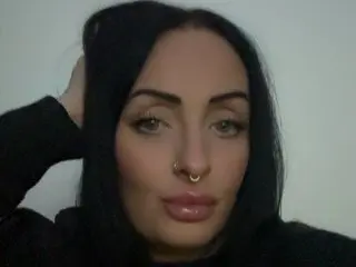FreyaRoseXXX has long black hair and a nose ring, looking directly at the camera with a neutral expression.