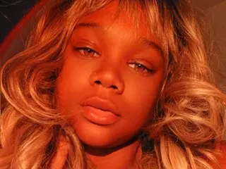 FuryKat92 looks directly at the camera with long, wavy blonde hair and a soft expression in a close-up headshot.
