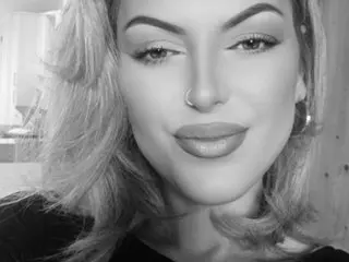 Gigi_Hernandez poses with a soft smile, showing her face, hair, and light makeup in a close-up black and white portrait.