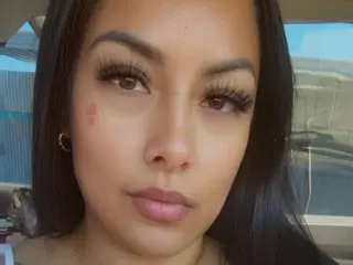 GoddessEmz looks directly at the camera with a close-up view of her face and long dark hair.
