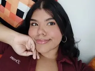 Hairylovegirl55 has long dark hair and a light smile, wearing a maroon top while resting her chin on her hand.