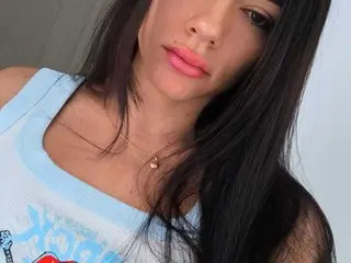 Hannah_Valencia poses with her long dark hair down, wearing a light blue tank top that shows her shoulders and neck.