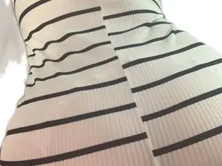 Close-up of a woman wearing a white and black horizontal striped ribbed knit midi dress.