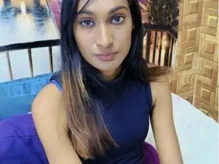 IndianRebel4u2Luv poses with her long dark hair down, wearing a dark blue sleeveless top while looking directly at the camera.